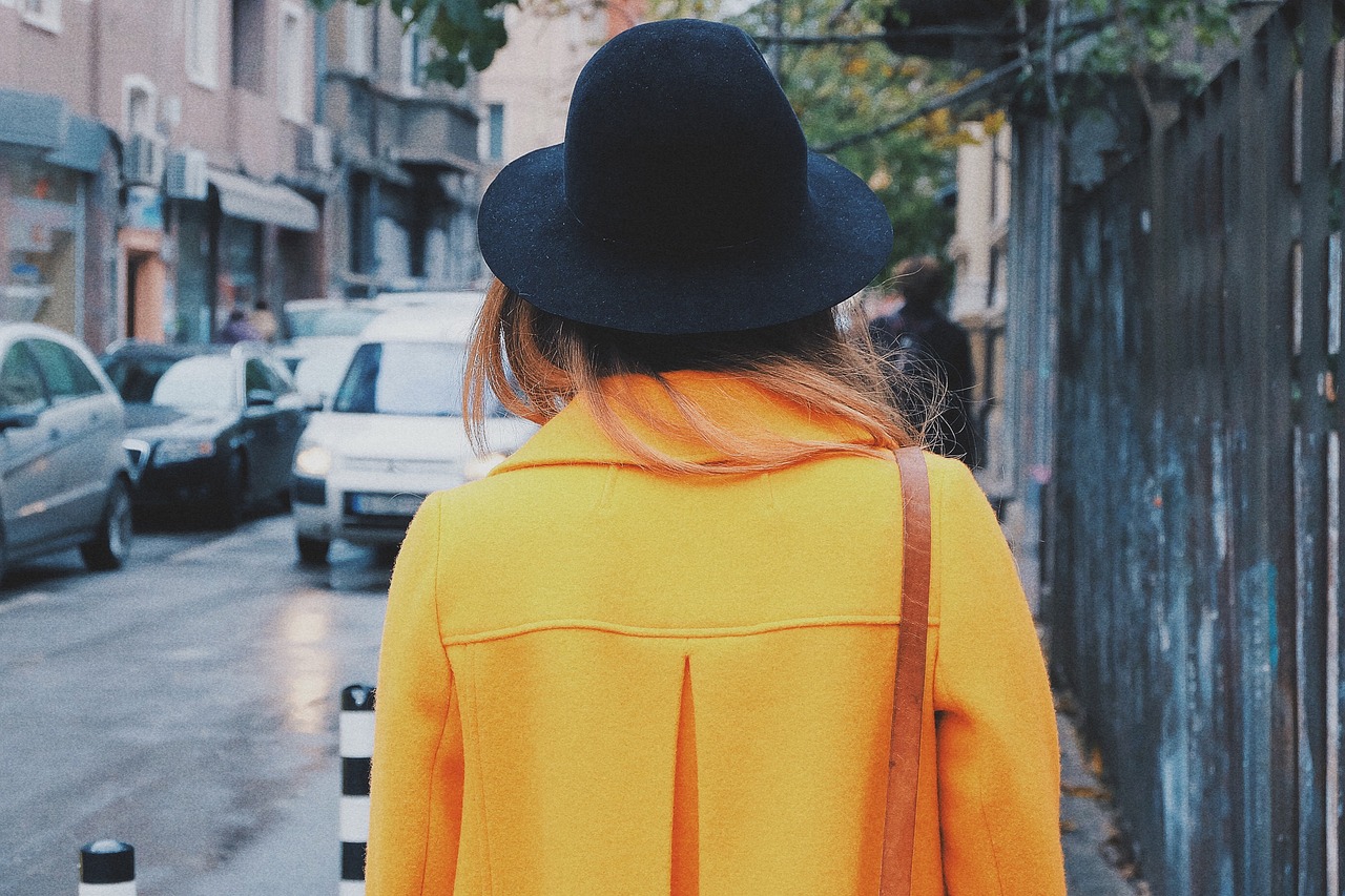 a person walking down the street in a yellow coat